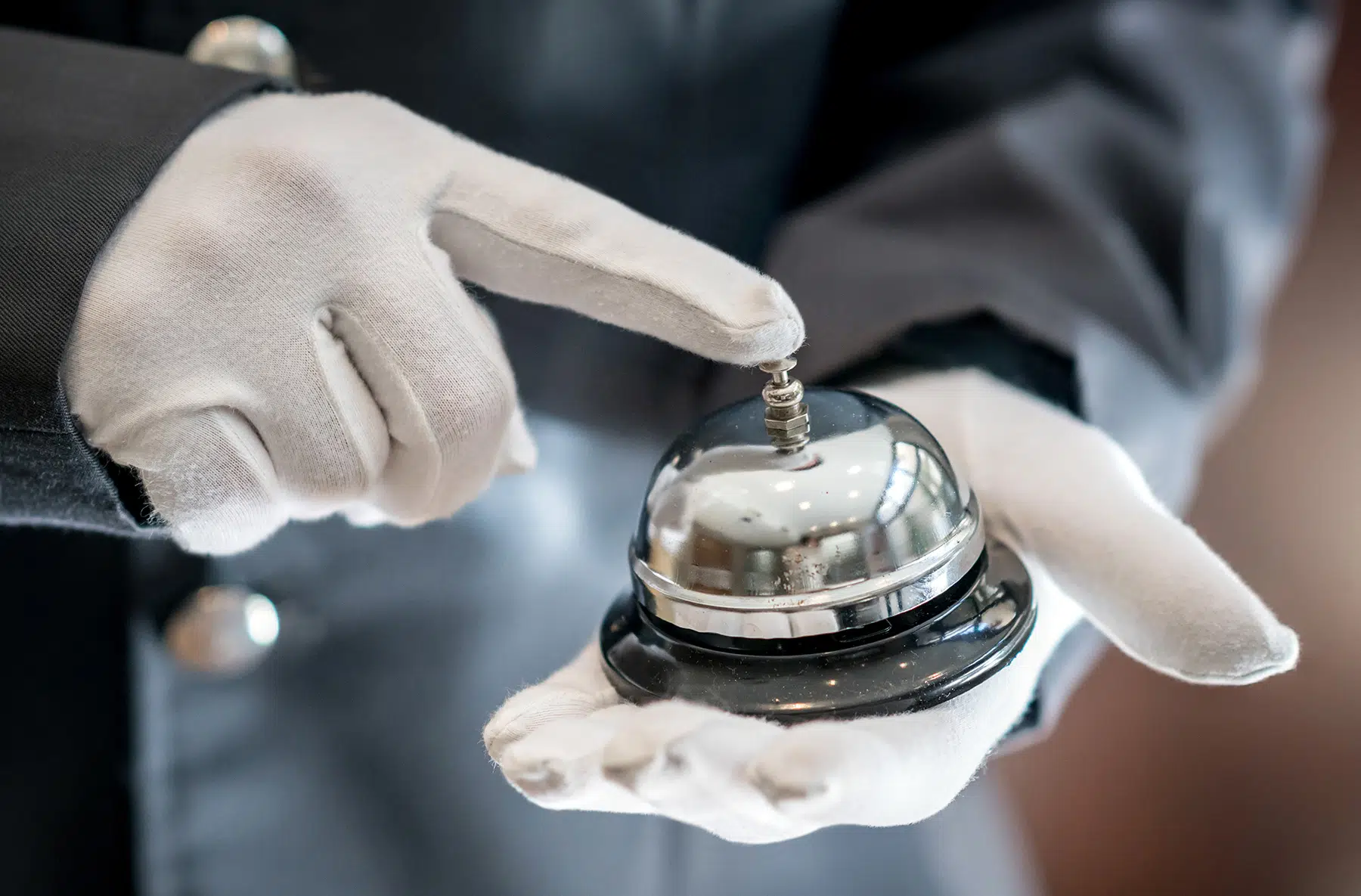NFCW Expo's concierge service. Picture of white gloved hands holding a hotel bell.